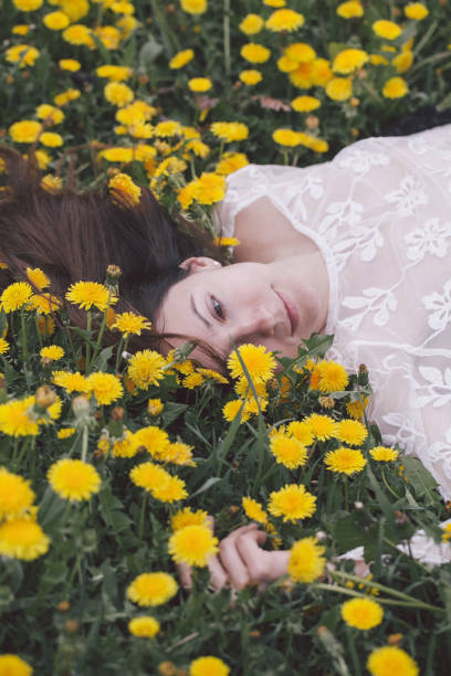 istock Young woman lying in dandelion 958730408