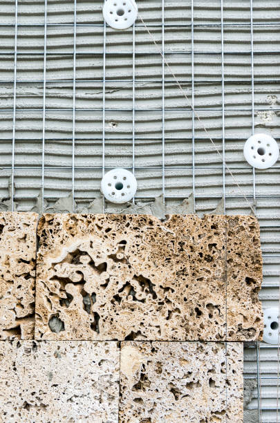 een gebouw in aanbouw, bekleed met stenen platen. - uitbeenhandschoen stockfoto's en -beelden