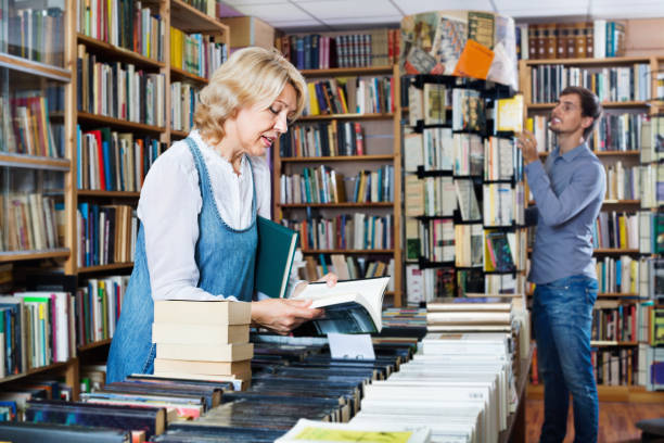 istock Mature smiling woman picking new book 958731322