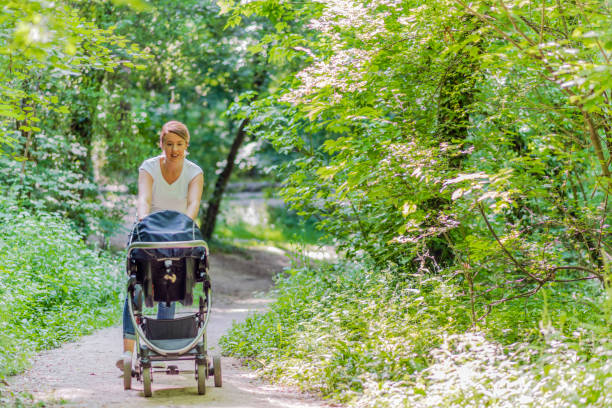 istock Mother walking her baby in public park 958731780