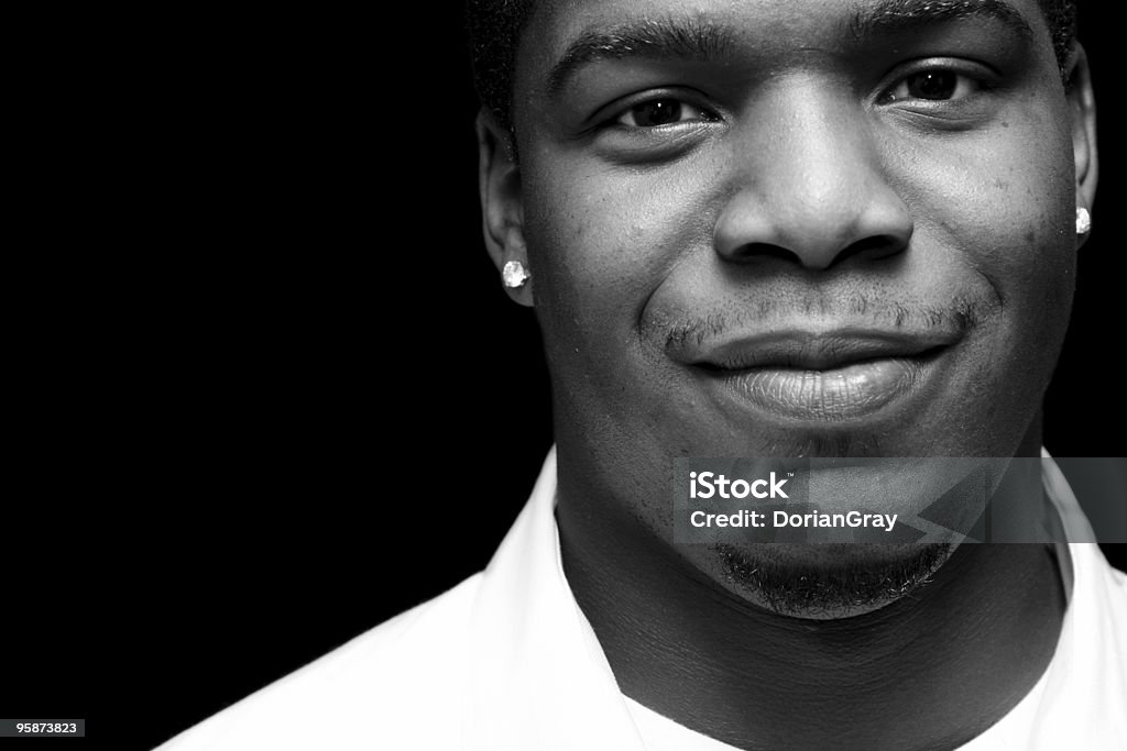 pleased black 20 something...looking genuinely content, shot in black and white, isolated on black Black And White Stock Photo