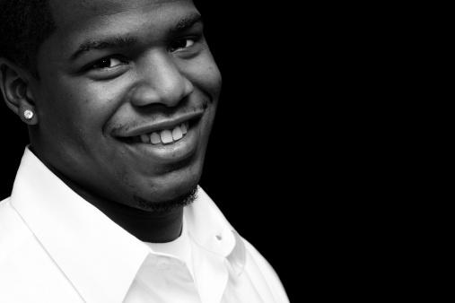 black 20 something...looking genuinely happy, shot in black and white, isolated on black