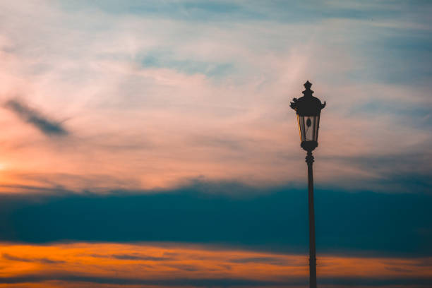 istock Old fashioned wrought iron street lamp at sunset 958739324