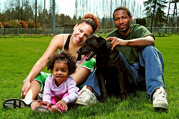 istock Family smiling in the park with dog 95874101