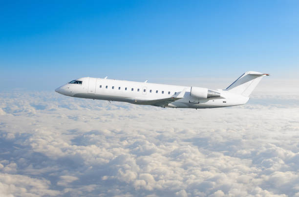 istock White airplane flies height, flight level high in the sky above the clouds blue sky. 958749206