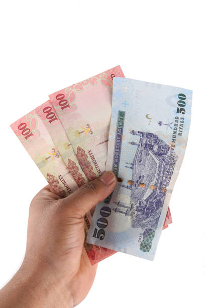 istock Saudi man counting thousands Saudi Riyal isolated on white background 958751708