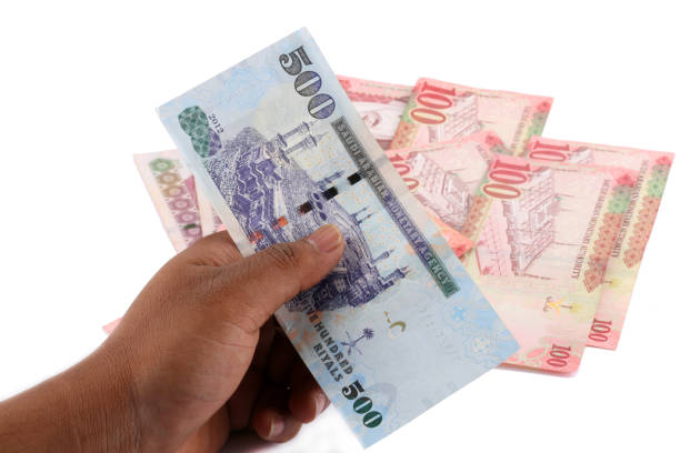 istock Saudi man counting thousands Saudi Riyal isolated on white background 958752134