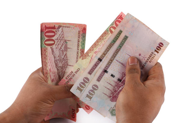 istock Saudi man counting thousands Saudi Riyal isolated on white background 958752444