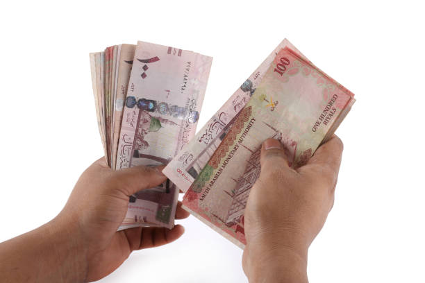 istock Saudi man counting thousands Saudi Riyal isolated on white background 958753140