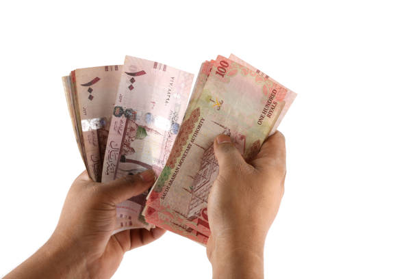 istock Saudi man counting thousands Saudi Riyal isolated on white background 958753284