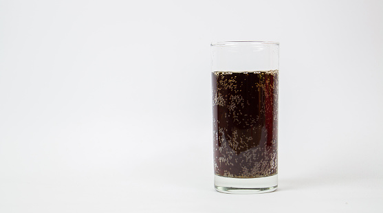 Highball glass with a cola soda pop drink.