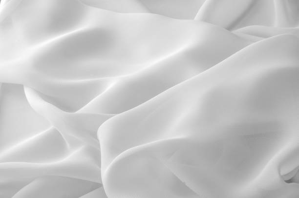 istock Texture, background, pattern. Silk fabric of white color, abstract folds. 958757146