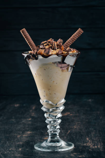 istock Ice-cream with caramel and nuts. On a black wooden background. Copy space. 958757606