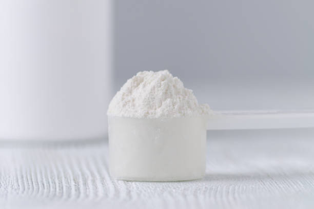 a scoop with white powder closeup and a jar on gray background a scoop with white powder closeup and a jar, on gray background tyrosine stock pictures, royalty-free photos & images