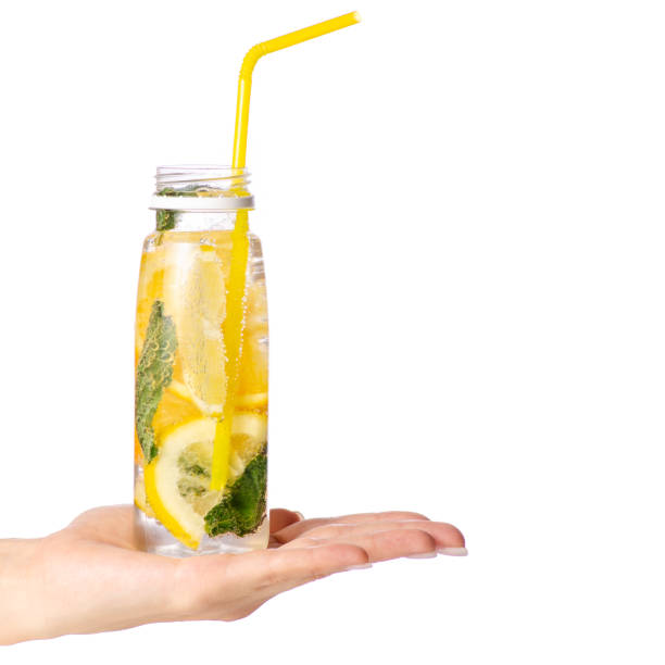 istock Bottle lemonade lemon orange with mint in hand 958765314
