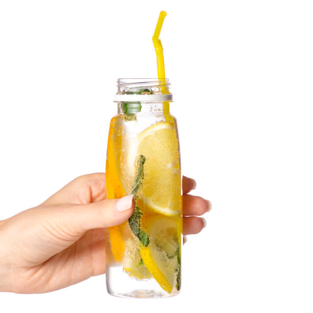 istock Bottle lemonade lemon orange with mint in hand 958765488