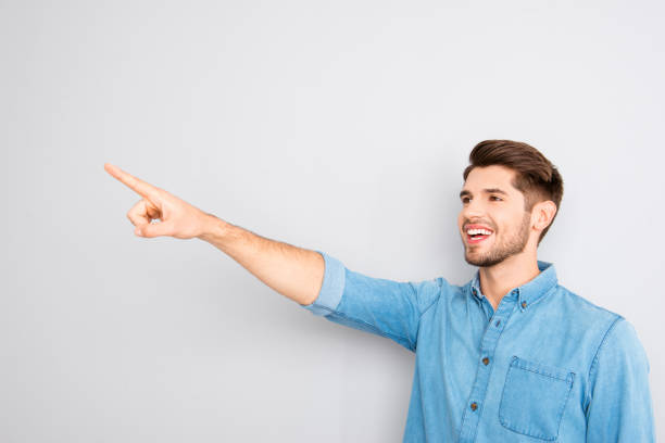 istock Handsome young man pointing with finger and showing smth 958766020
