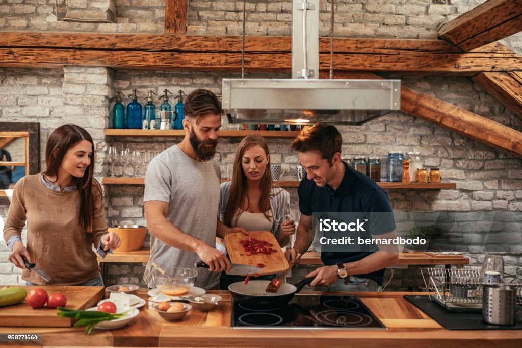 Friends who eat together, stay together Group of friends preparing a meal together. Friendship Stock Photo