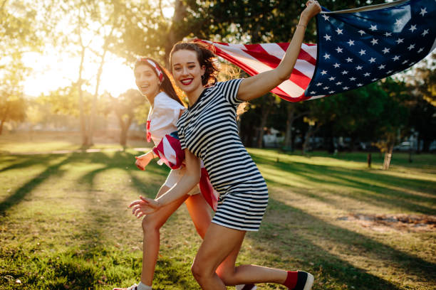 istock Female friend running with American flag 958777054
