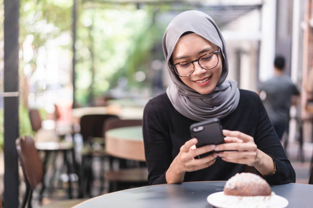 istock Muslim girl during lunch break checking email. 958784978