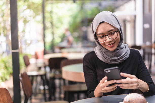 istock Muslim girl during lunch break checking email. 958784984