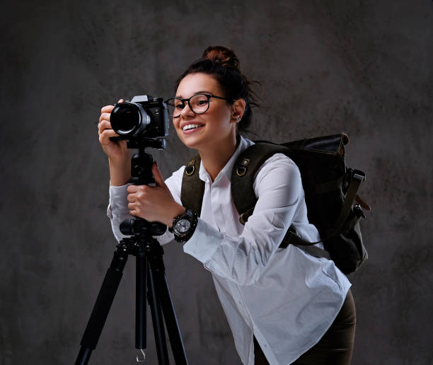 istock Female taking pictures with a digital camera on a tripod. 958789714