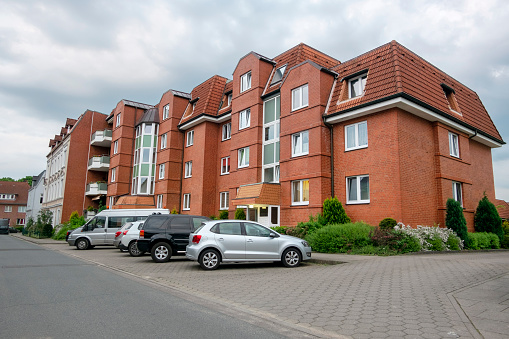 large german apartment building from social housing with parked vehicles in front of it