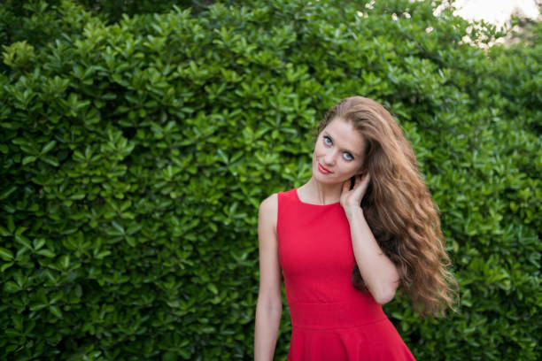 istock Beautiful woman in red at the park 958793376