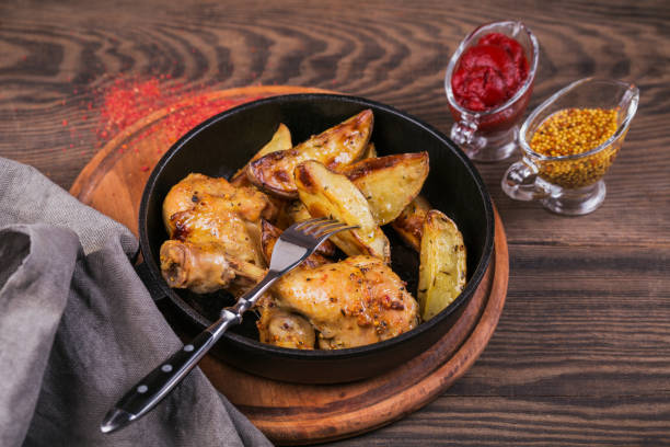 istock Fried chicken legs with fried potatoes in pan 958793594