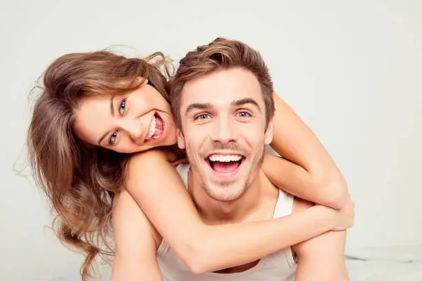 Cheerful smiling couple in love hugging in the bedroom