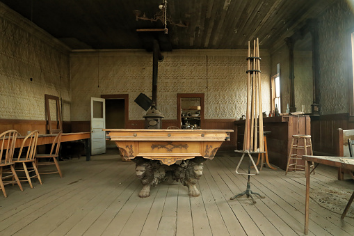 Bodie, California- July 15,2014: pool play room, lion-legged pool table in a ghost town, cable poles