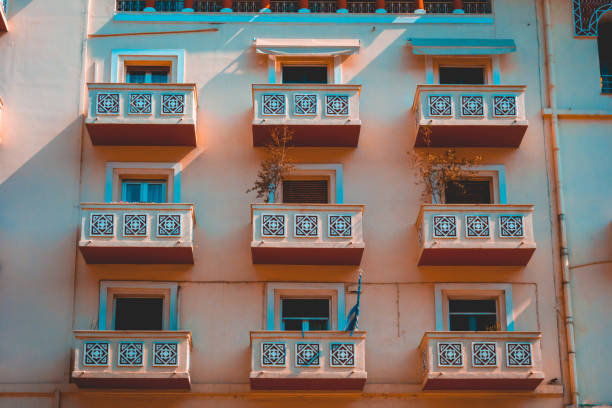 istock beautiful building facade with orange balcony and blue shadows 958799088