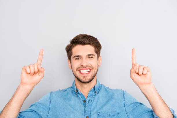 istock Handsome man with beaming smile gestyring with fingers 958799158