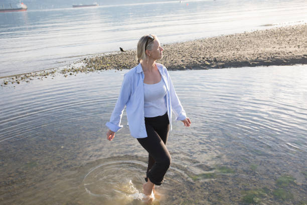 istock Mature woman explores beach in morning light 958800546