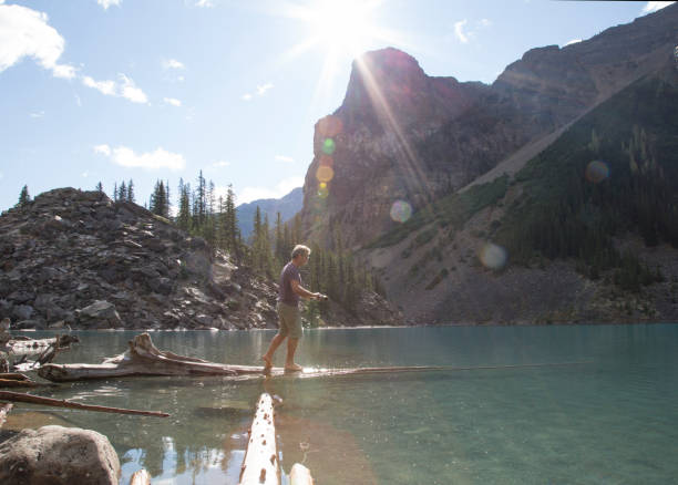 istock Man walks out on log over Moraine Lake 958800594