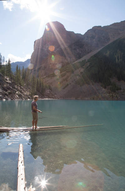 istock Man walks out on log over Moraine Lake 958800662