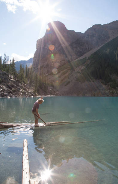 istock Man walks out on log over Moraine Lake 958800676