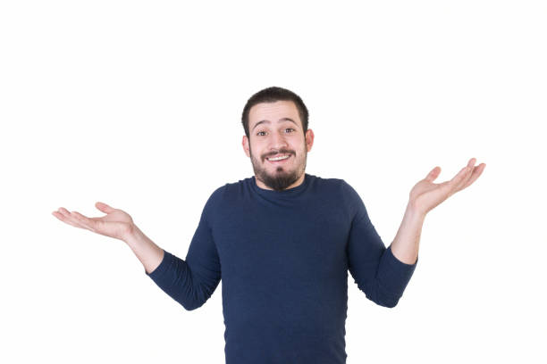 Portrait of shrugging young man on a white background Portrait of shrugging young man on a white background. Horizontal composition. Studio shot. confusion raised eyebrows human face men stock pictures, royalty-free photos & images