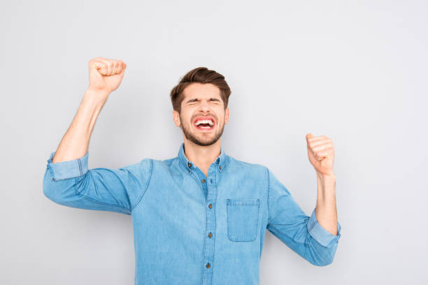 istock Happy glad man celebrating victory with raised fists 958808914