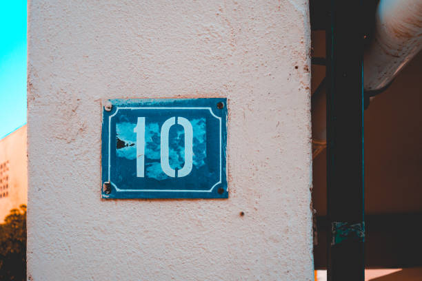 istock blue number 10 door sign on white facade 958819900