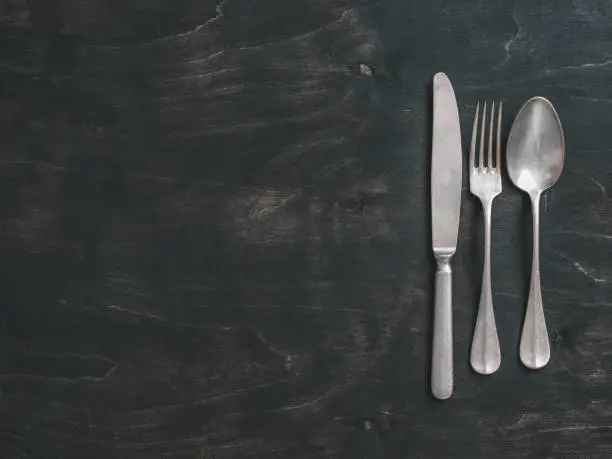 Photo of Vintage cutlery on dark background, copy space