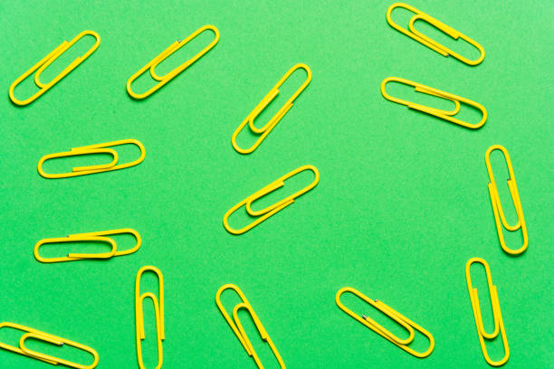 istock Yellow paperclips on green background 958821426