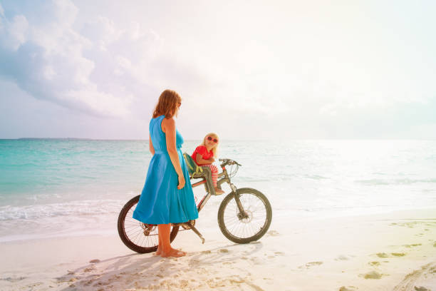 istock mother and little daughter biking at beach 958825666