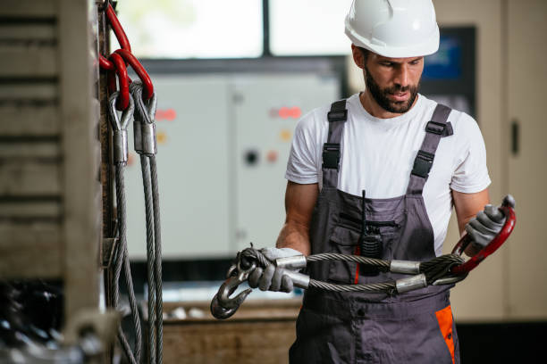 istock Manual worker with carabiners in factory 958830380
