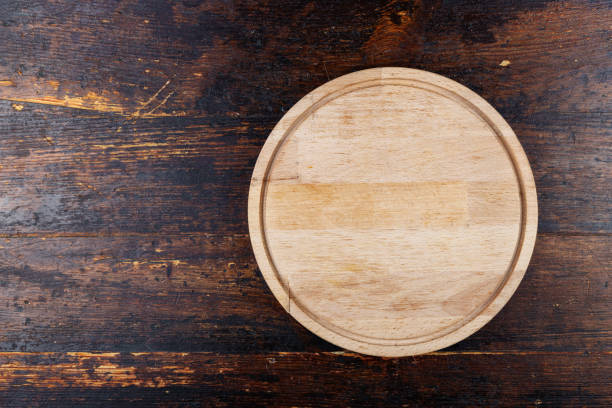 istock round pizza board on a dark brown wooden background. 958831254