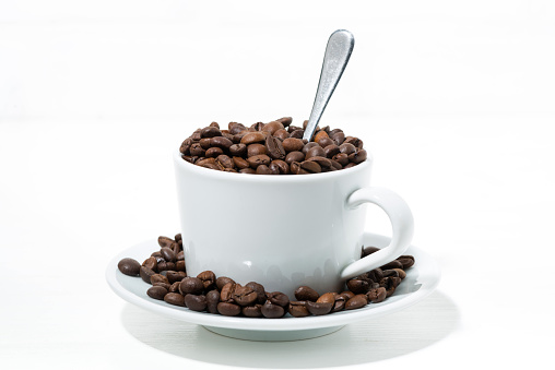 cup with coffee beans on white background, concept photo closeup