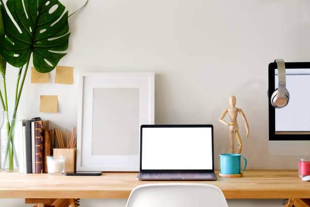 istock Mockup blank screen laptop and poster on artist workspace. 958835438
