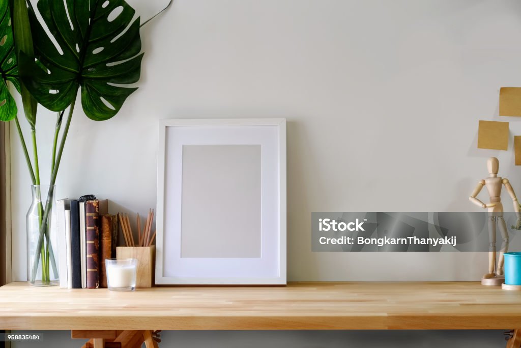 Mockup poster on wooden table with copy space. Picture Frame Stock Photo