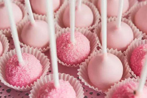 Platter of cake pops with pink icing, closeup. Candy bar and catering concept for birthday, wedding and other holiday celebration