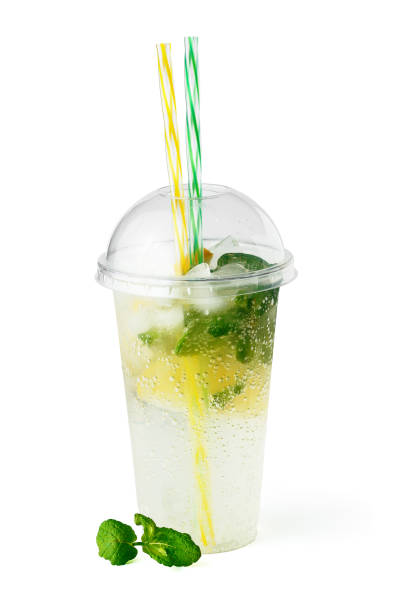 Cooling lemonade drink in plastic glass with lemon slices, mint and sparkling water isolated on white background